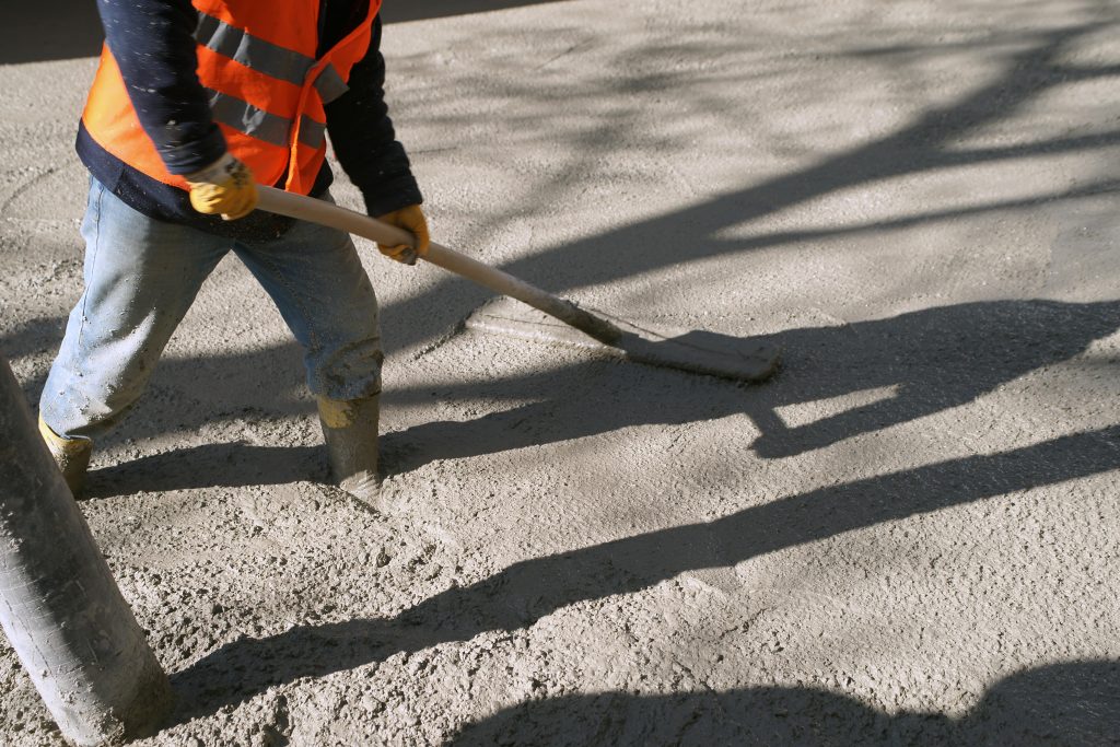 close up of a man brushing a wet concrete driveway | EasyMix Concrete Ltd.